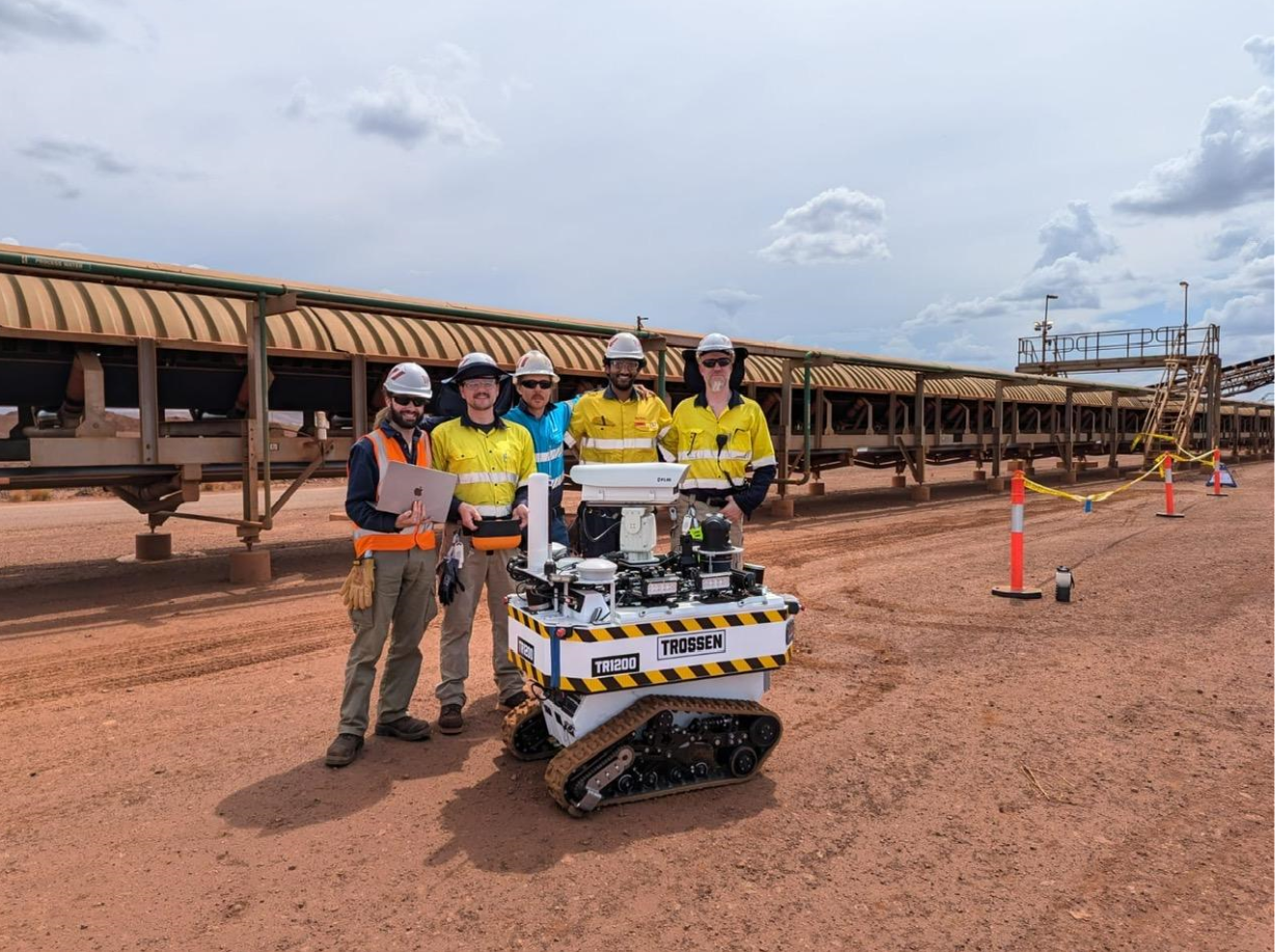 A group of engineers with a tracked robot in a testing facility