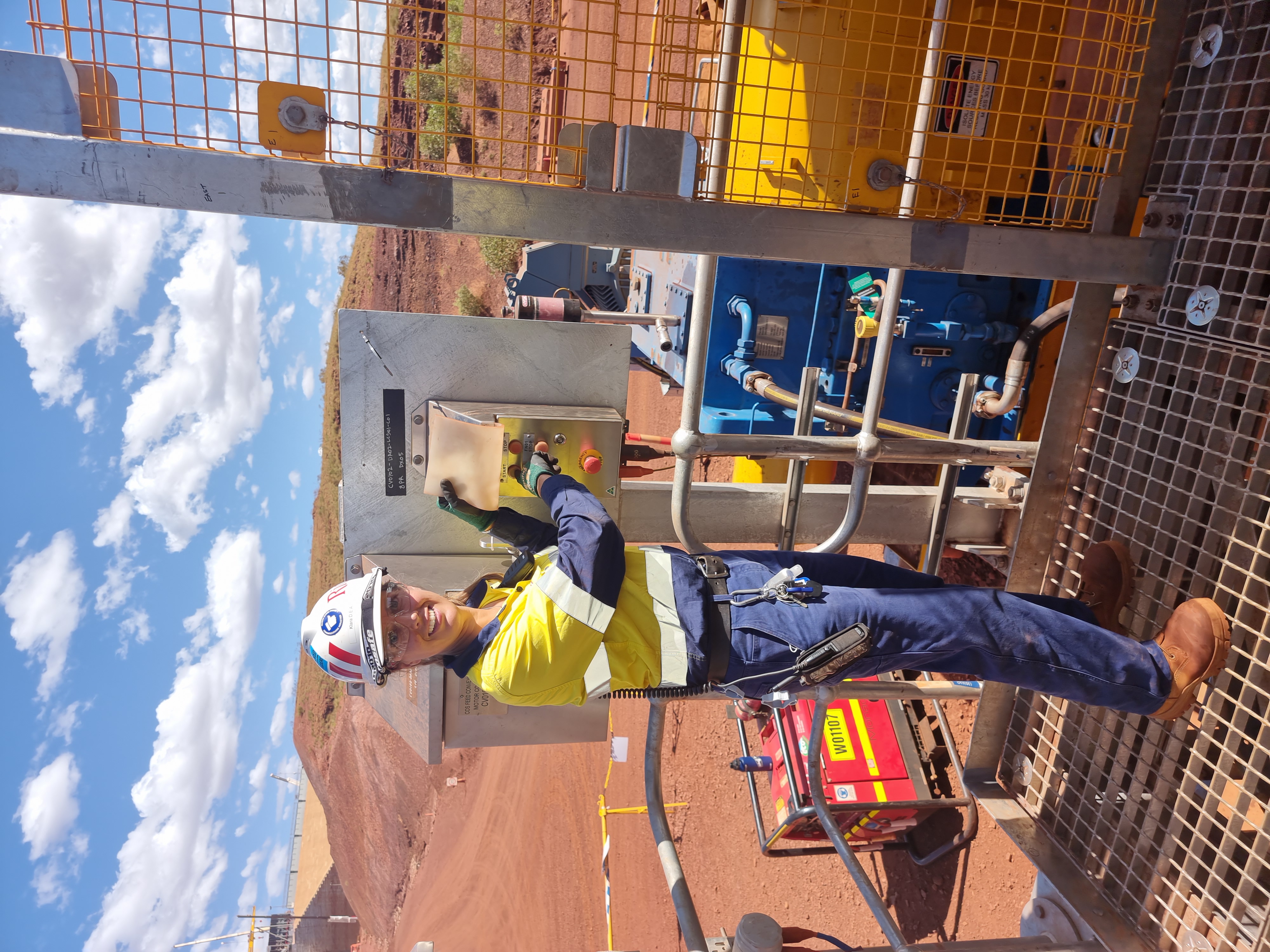 women push machine button on mine site